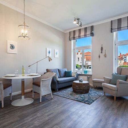 Innenansicht des Appartements Flamingo mit Sofas vor zwei Fenstern
