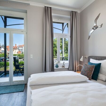 Das Bett im Appartement Flamingo mit großen Fenstern