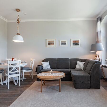 Appartement Gloria - Modernes Wohnzimmer mit einem bequemen Ecksofa und einem Holztisch