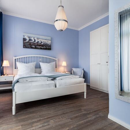 Appartement Gloria - Modernes Schlafzimmer mit blauen Wänden und hellem Holzfußboden