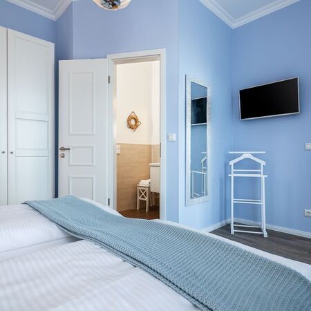 Appartement Gloria - Modernes Schlafzimmer mit blauen Wänden und Fernseher