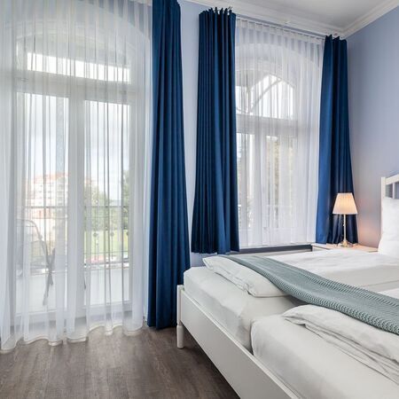 Appartement Gloria - Modernes Schlafzimmer mit blauen Wänden und hellem Holzfußboden