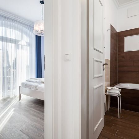 Appartement Lolita - Helle Ansicht eines Schlafzimmers mit angrenzendem Badezimmer