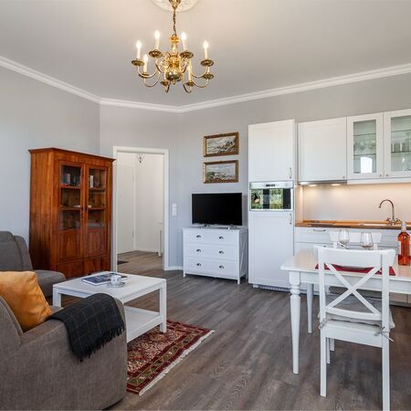 Appartement Lolita - Helle Küche im Wohnzimmer mit modernen Geräten und Holzregalen