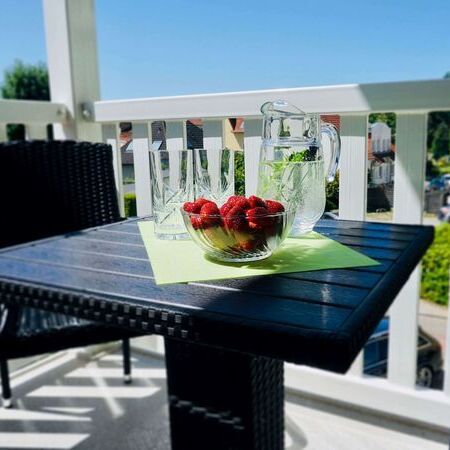 Appartement Kronenburg - Einladendes Wohnzimmer mit Kunstwerken an der Wand und Balkonblick