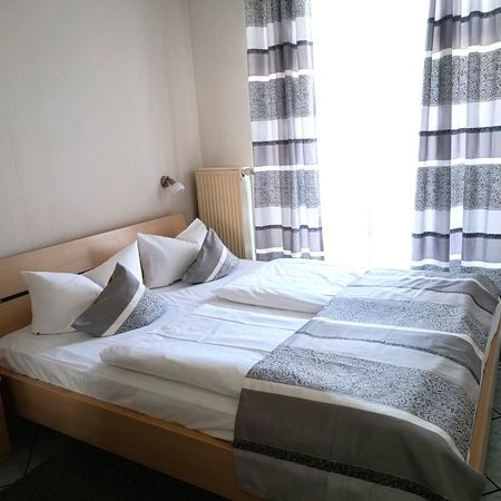 Helles und einladendes Schlafzimmer mit Fenster und Vorhängen