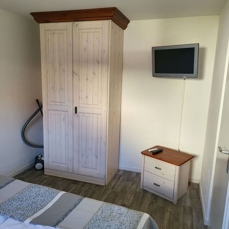 TW 103 Rosenhof Appartement - Schrank und Nachttisch in einem hellen Schlafzimmer