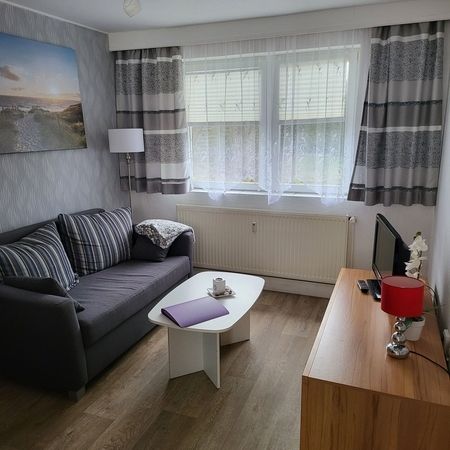TW 103 Rosenhof Appartement - Stilvolles Wohnzimmer mit dekorativen Elementen und angenehmer Beleuchtung