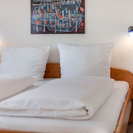 Doppelbett mit weißen Kissen und Decken in einem stilvollen Schlafzimmer