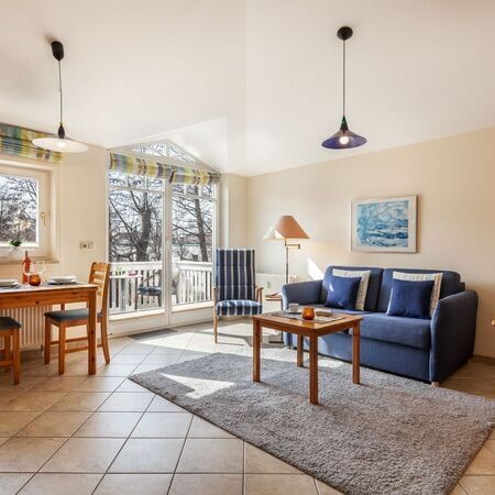 Lichtdurchflutetes Wohnzimmer mit großen Fenstern und stilvollem Dekor