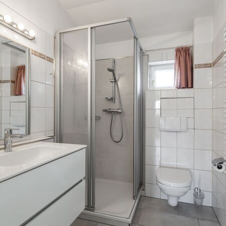 Komfortables Badezimmer mit Dusche und Handtüchern