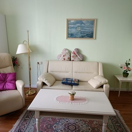 Helles Wohnzimmer mit beigem Sofa und dekorativen Kissen