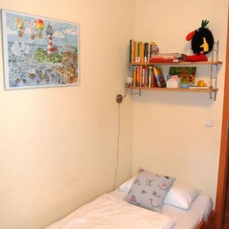Bunte Wandkunst über einem Einzelbett in einem Kinderzimmer