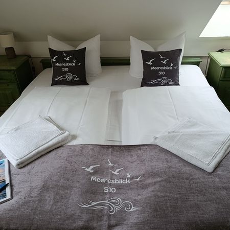Gemütliches Schlafzimmer mit Meerblick und dekorativen Kissen