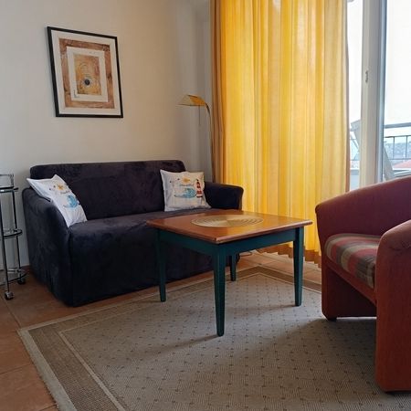 Helles Wohnzimmer mit großen Fenstern und warmen Farbtönen