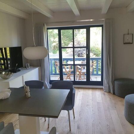 Modernes Wohnzimmer mit Blick auf die Terrasse und Garten