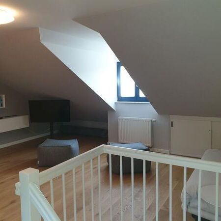 Helles Dachzimmer mit Fenster und gemütlicher Sitzecke