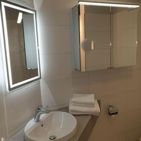 Helles Badezimmer mit LED-Beleuchtung und Spiegel