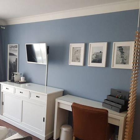 Der Fernseher und eine weiße Kommode im Doppelzimmer 101