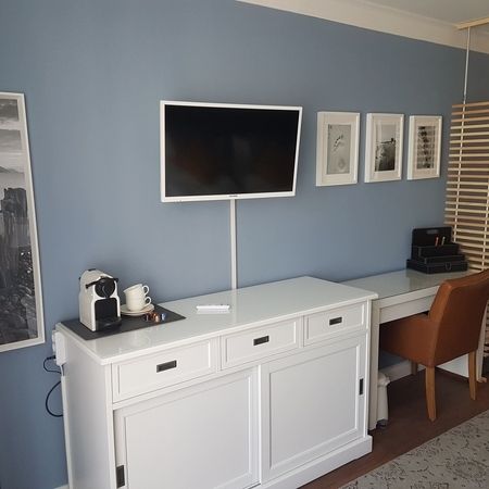Der Fernseher und eine weiße Kommode im Doppelzimmer 101