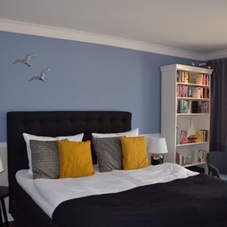 Das Bett im Doppelzimmer 101 mit grauen Kissen