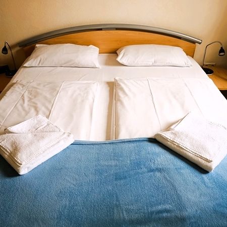 Frische Handtücher auf einem Bett mit blauer Decke