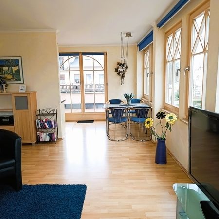 Lichtdurchflutetes Wohnzimmer mit Holzfußboden und gemütlicher Atmosphäre