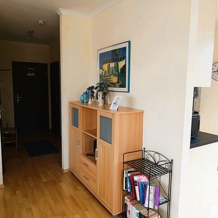 Ein Flur mit einem Holzschrank und einem Gemälde an der Wand