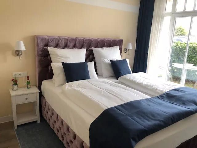 Appartement Elegance Rosenhof - Helles modernes Schlafzimmer mit einem Doppelbett und großen Fenstern