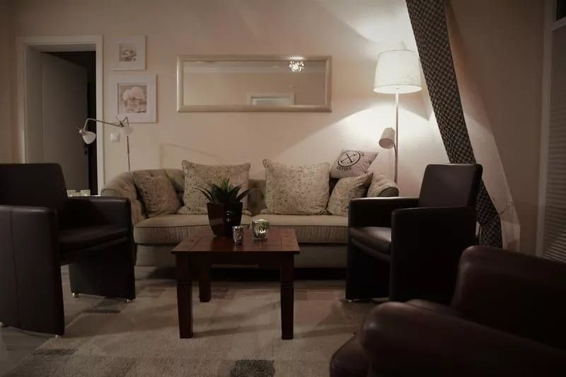 Valencia Rosenhof - Gemütliches Wohnzimmer mit Sofa, Tisch und Stehlampe