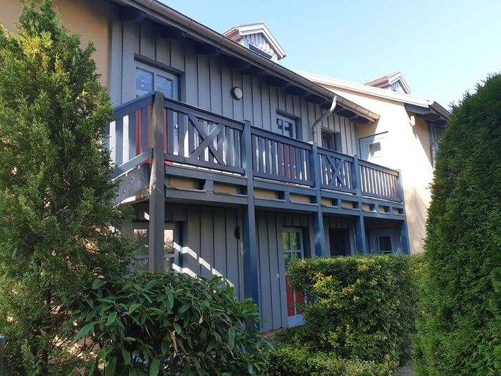 Haus mit blauer Fassade und grüner Umgebung